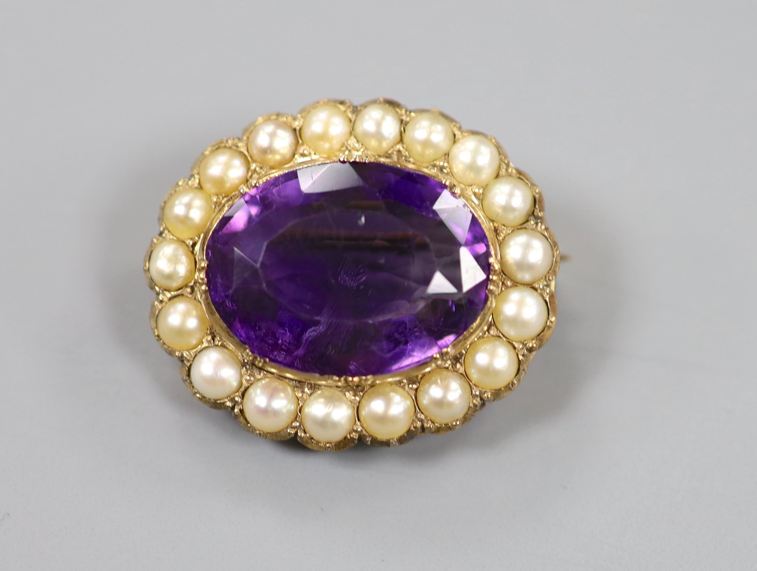 A late Victorian yellow metal, amethyst and split pearl set oval brooch, 28mm, gross weight 10.3 grams.